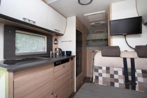 a small kitchen with a tv and a kitchen in an rv at Encar - Bliżej nie będzie in Zator