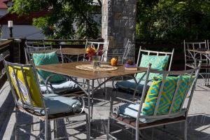 a wooden table and chairs with pillows on a patio at Roberto Hotel in Sinaia
