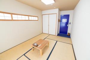 um quarto com um banco no meio em K's House Kyoto -Travelers Hostel em Quioto