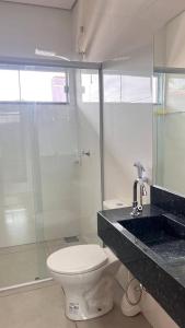 a bathroom with a toilet and a glass shower at Casa Piscina Centro BonitoMS in Bonito +20 photos
