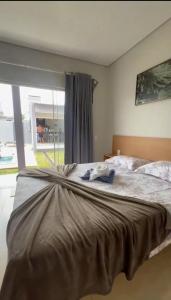 a bedroom with a large bed with a large window at Casa Piscina Centro BonitoMS in Bonito