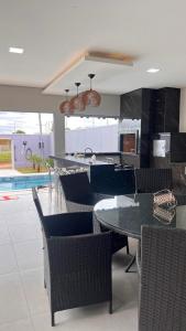 a dining room with tables and chairs and a pool at Casa Piscina Centro BonitoMS in Bonito
