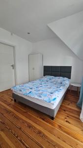 a large bed in a room with a wooden floor at Pokoje u Honi in Pobierowo