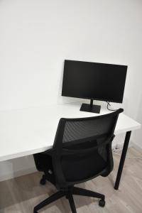 a computer monitor sitting on top of a white desk at Spacieux F2 - Louvroil - Proche Belgique in Louvroil
