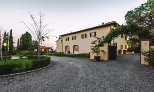 a large white house with a driveway at Il Principino Country Resort in Vinci