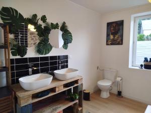 a bathroom with two sinks and a toilet at Parenthèse Aiyanna in Moux-en-Morvan