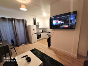 Una sala de estar con un televisor de pantalla plana en una pared. en 4 Bedroom House 8min walk to EastHam Station, en Londres
