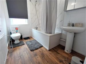 Un baño con bañera, lavabo e inodoro. en 4 Bedroom House 8min walk to EastHam Station, en Londres 13 fotos más