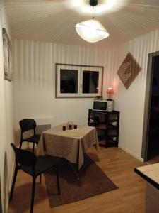 a room with a table and chairs and a microwave at Parenthèse Aiyanna in Moux-en-Morvan