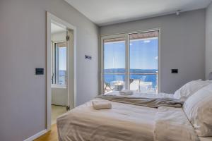 a bedroom with a large bed with a view of the ocean at Villa Rosciola in Crikvenica +84 photos