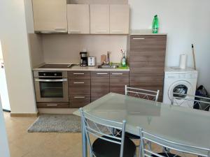 a kitchen with a table and chairs and a sink at 2 Room Apartment Costa Calma Aheloy Bulgarien in Aheloy