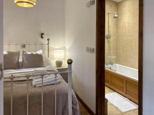 een slaapkamer met een bed en een badkamer met een bad bij Oak in Falmouth