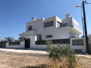 a white house with a lot of windows at Toska Residence in Loutraki