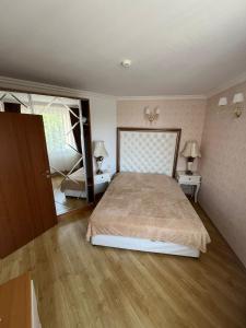 Un dormitorio con una cama grande y dos mesas con lámparas. en Sweet Home, en Sunny Beach