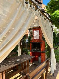 Una mesa de picnic de madera con dosel y un banco. en Sweet Home, en Sunny Beach