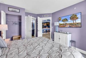 a bedroom with a large bed and purple walls at 19th Floor Oceanfront - Panoramic Views - Sleeps 10 - Caribbean Resort in Myrtle Beach +22 photos