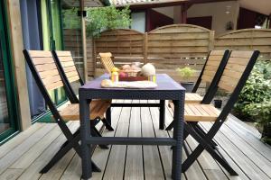 a black table and two chairs on a patio at Maison, Piscine sous les pins in Moliets-et-Maa