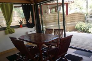 a wooden table and chairs in a room with a porch at Maison, Piscine sous les pins in Moliets-et-Maa +20 photos