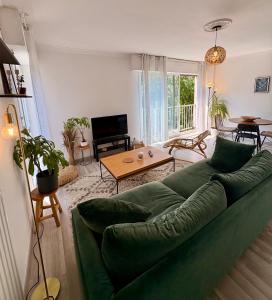 ルーアンにあるAppartement Rouen centre proche CHUの緑のソファとテーブルのあるリビングルーム