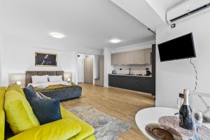 a living room with a yellow couch and a kitchen at One SeaView std in Infinity Pool & Spa Resort in Mamaia Sat/Năvodari +44 photos