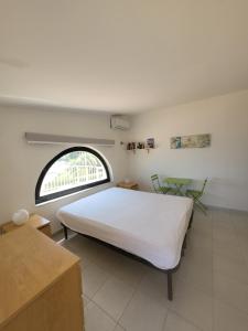 a bedroom with a large white bed and a window at Villa Stella in Fontane Bianche