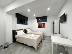 a room with two beds and a table and a refrigerator at UpArtments in Potos