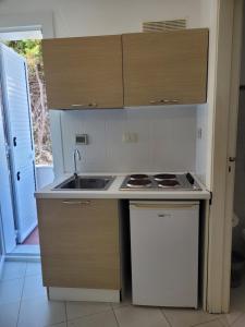 a small kitchen with a sink and a stove at Villa Stella in Fontane Bianche