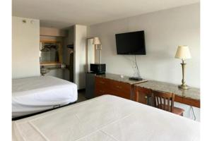 a hotel room with a bed and a flat screen tv at Motel 6 Laurel, MS in Laurel