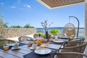 a wooden table with food and drinks on a patio at Villa Rosciola in Crikvenica