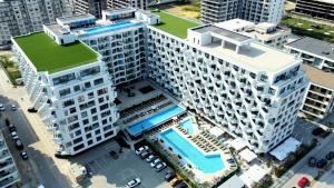 an overhead view of a large white building with a pool at One SeaView std in Infinity Pool & Spa Resort in Mamaia Sat/Năvodari