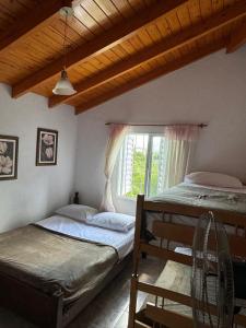 two beds in a room with a window at Casa vista panorámica al lago in Córdoba