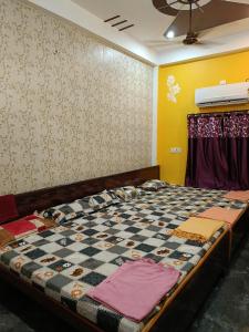 Una cama en una habitación con una pared con diseño de tablero de ajedrez. en janki paying guest house, en Ayodhya 23 fotos más