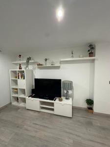 a white living room with a flat screen tv at Apartment in Palmela - Close to Beaches and Mountains! in Palmela