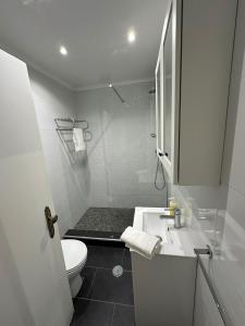 a white bathroom with a sink and a toilet at Apartment in Palmela - Close to Beaches and Mountains! in Palmela