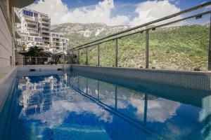 a swimming pool with a view of a mountain at Montehome sea view in Bečići