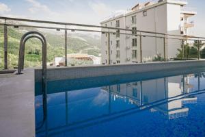 a swimming pool in front of a building at Montehome sea view in Bečići