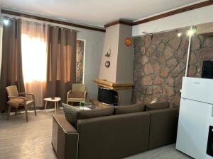 a living room with a couch and a stone wall at Petrino view at vafios in Vafiós