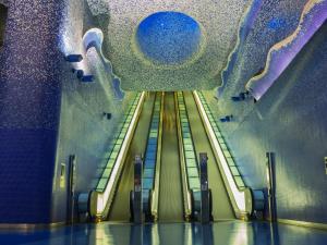 an escalator in a subway station with a blue ceiling at Incoming Quartieri Spagnoli in Naples