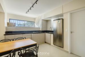 a kitchen with a wooden table and a refrigerator at Apto de 2Q, completo, Asa Norte - CGS0002 in Brasilia
