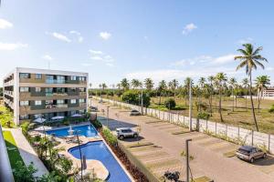 une vue aérienne sur un bâtiment et un parking dans l'établissement Resort Mana Beach Experience in Muro Alto, à Porto de Galinhas