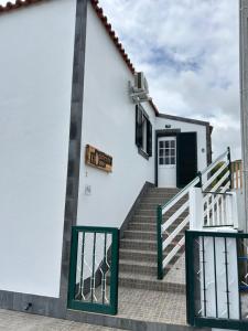 圣克鲁什达什弗洛里什Ocidente House的一栋有楼梯和大门的白色建筑