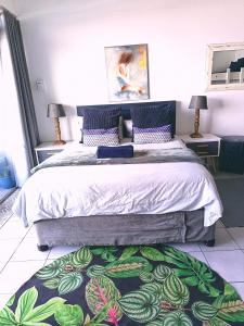 a bedroom with a large bed with a rug on the floor at Umdloti Beach Resort 608 in Durban +12 photos