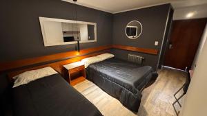 a small bedroom with two beds and a mirror at ACA Villa Bordeu in Bahía Blanca