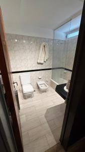 a bathroom with a toilet and a sink at ACA Villa Bordeu in Bahía Blanca +16 photos