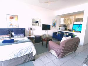 a bedroom with a bed and a couch and a tv at Umdloti Beach Resort 608 in Durban