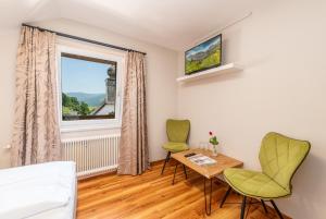 a bedroom with a table and two chairs and a window at Hotel Kollerhof in Aich