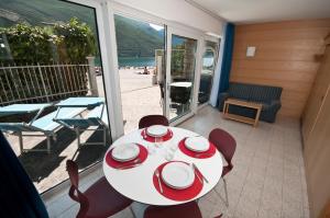 a dining room with a table and chairs on a balcony at Casa Toblini al Lago on the beach in Nago-Torbole