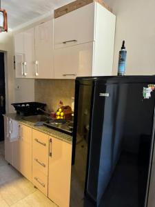 a kitchen with a black refrigerator and a sink at Aqua View Studio in Dawwār Abū Maḩrūs