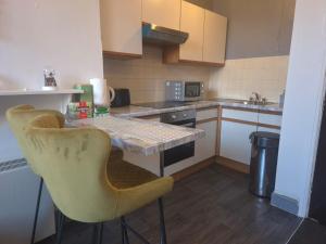 a small kitchen with a table and two chairs at 1 Bed Apartment - Sleeps 4 - City Centre in Wolverhampton