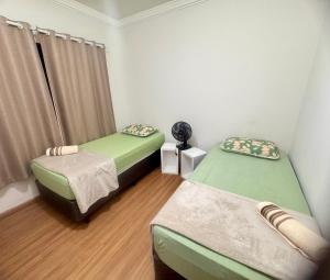 a room with two twin beds and a window at Casa aconchegante em Araxá in Araxá
